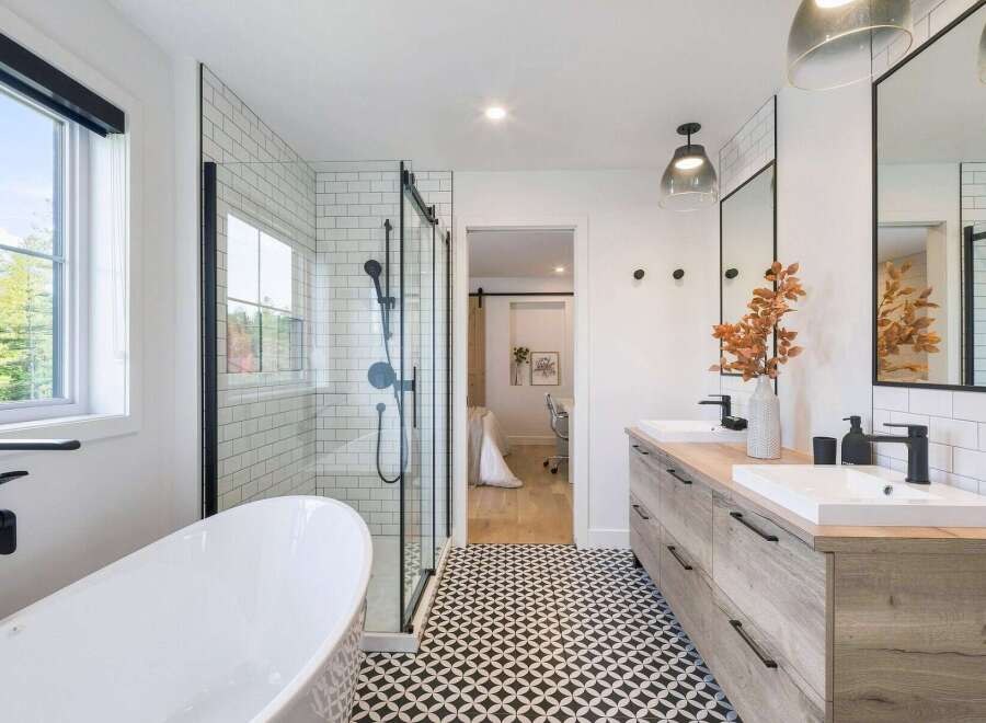 This modern bathroom features a freestanding soaking tub and a sleek glass-enclosed shower with subway tile.
