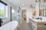 This modern bathroom features a freestanding soaking tub and a sleek glass-enclosed shower with subway tile.