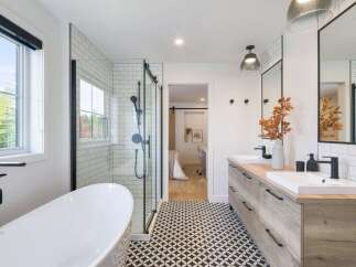 This modern bathroom features a freestanding soaking tub and a sleek glass-enclosed shower with subway tile.