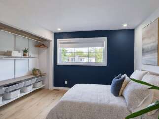 Discover this beautifully designed bedroom featuring a striking navy accent wall that adds a touch of sophistication.