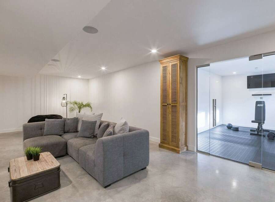 This modern living space features a spacious grey sectional sofa complemented by a rustic wooden coffee table, perfect for relaxation and entertaining.