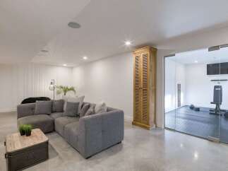 This modern living space features a spacious grey sectional sofa complemented by a rustic wooden coffee table, perfect for relaxation and entertaining.