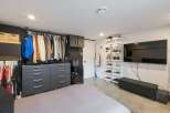 Discover organized living with this spacious bedroom featuring ample storage solutions.