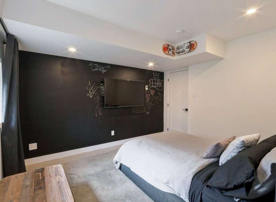 This modern bedroom features a unique chalkboard wall, perfect for creative expression or leaving notes.