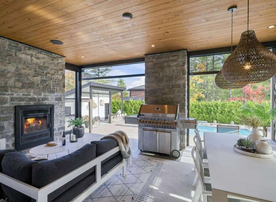 Experience luxurious outdoor living with this stunning covered patio, featuring a cozy fireplace and a state-of-the-art grill perfect for entertaining.