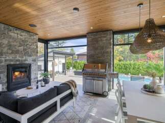 Experience luxurious outdoor living with this stunning covered patio, featuring a cozy fireplace and a state-of-the-art grill perfect for entertaining.