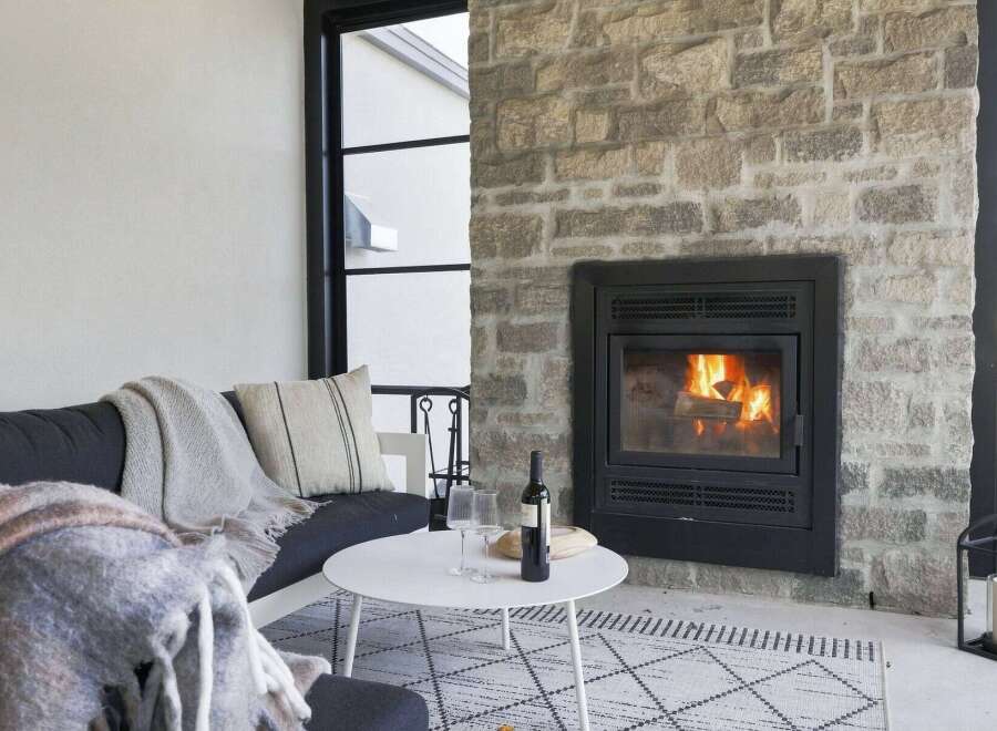 Cozy up by the fire in this inviting living space, featuring a stunning stone fireplace as the centerpiece.