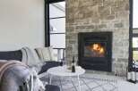 Cozy up by the fire in this inviting living space, featuring a stunning stone fireplace as the centerpiece.