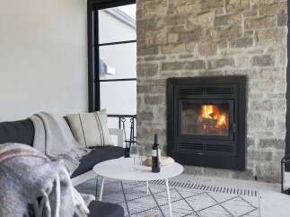 Cozy up by the fire in this inviting living space, featuring a stunning stone fireplace as the centerpiece.