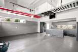 This spacious garage boasts ample storage solutions, including overhead racks and extensive cabinetry, perfect for organizing tools and equipment.
