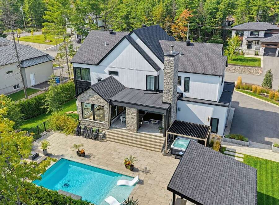 Experience luxury living in this stunning modern home featuring a pristine swimming pool and a relaxing hot tub, perfect for unwinding.