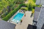 Experience luxury outdoor living with this stunning backyard oasis, featuring a pristine swimming pool surrounded by a spacious stone patio.