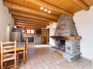 Experience rustic charm in this mountain retreat featuring a grand stone fireplace, perfect for cozy evenings.