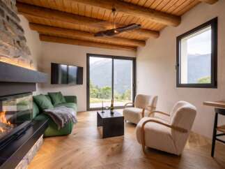 Experience ultimate relaxation in this cozy living room, featuring a modern fireplace and plush green sofa.