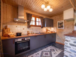 Experience rustic charm in this beautifully appointed kitchen, featuring warm wooden paneling and a modern grey cabinetry.