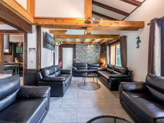 Experience ultimate comfort in this spacious living room, featuring plush black leather sofas arranged for conversation and relaxation.