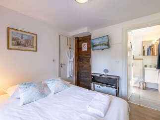 Experience comfort and convenience in this charming hotel room, featuring a plush queen-sized bed adorned with decorative pillows and crisp white linens.