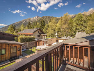Experience the charm of mountain living in this picturesque property, nestled amidst lush greenery and towering peaks.