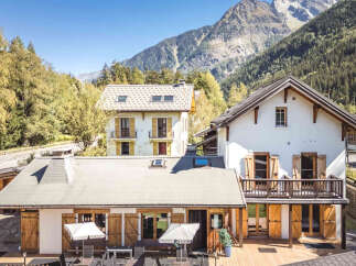Experience alpine living in this charming property nestled against a majestic mountain backdrop.