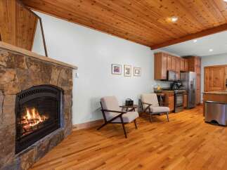 Cozy living space featuring a stunning stone fireplace with a roaring fire, perfect for chilly evenings.