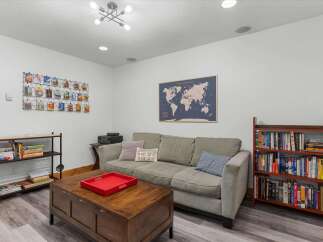 This cozy living room features a comfortable gray sofa adorned with decorative pillows, including one displaying coordinates for Steamboat.