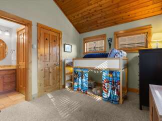 This charming bedroom features a playful loft bed with fun character curtains, perfect for a child's space.