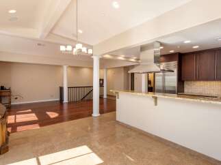 Experience modern living in this spacious open-concept home featuring a gourmet kitchen with rich wood cabinetry, granite countertops, and a sleek stainless steel range hood.