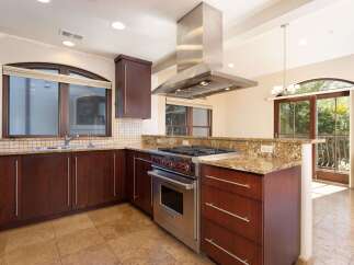 Experience culinary excellence in this stunning kitchen, featuring rich cherry wood cabinetry and a professional-grade Wolf range.