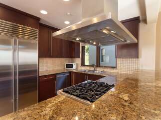 Experience luxury in this stunning kitchen featuring a professional-grade gas range and a sleek stainless steel hood.