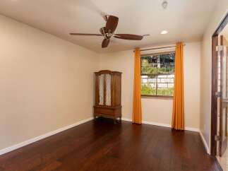 This charming room features rich hardwood floors and a beautiful wooden armoire, offering ample storage and a touch of classic elegance.