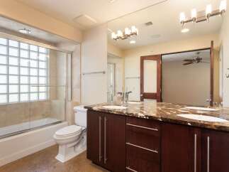 This luxurious bathroom features a spacious vanity with a granite countertop and dual sinks, perfect for busy mornings.