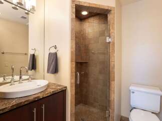 Experience luxury in this modern bathroom featuring a spacious walk-in shower with elegant stone tile and a sleek glass enclosure.