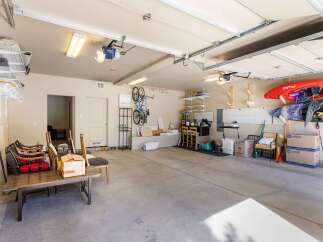 This spacious garage offers ample storage solutions, including wall-mounted shelving and a pegboard system, perfect for organizing tools and equipment.