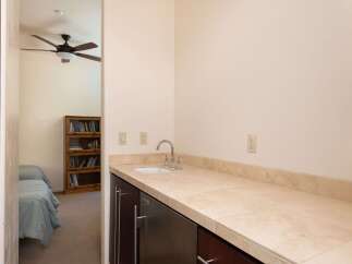 This charming space features a convenient wet bar area with a sink and ample counter space, perfect for entertaining.