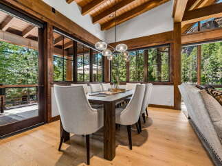 Experience luxurious mountain living in this stunning dining room, featuring a grand wooden dining table surrounded by elegant upholstered chairs.