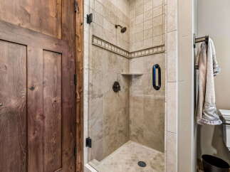 Experience luxury in this stunning bathroom featuring a spacious walk-in shower with elegant tile work and a convenient built-in shelf.