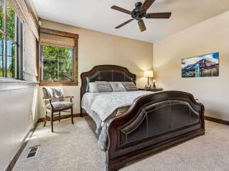 Experience rustic charm in this inviting bedroom, featuring a luxurious dark wood sleigh bed with leather upholstery.