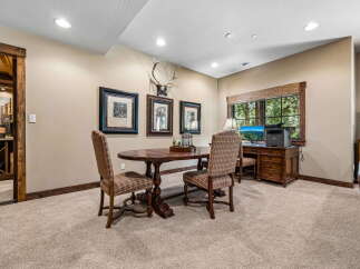 This inviting space features a rustic wooden dining table with plaid chairs, perfect for intimate gatherings.