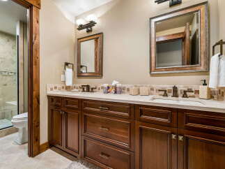 Experience luxury in this stunning bathroom featuring a spacious double vanity with elegant wood cabinetry and marble countertops.