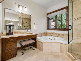 Indulge in luxury in this stunning bathroom featuring a spacious corner jacuzzi tub perfect for relaxation.