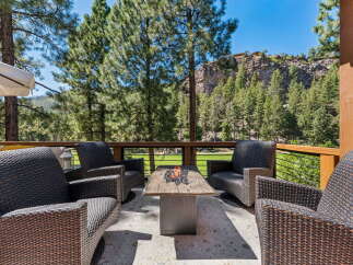 Enjoy breathtaking mountain views from this stunning outdoor living space, complete with a cozy fire pit and comfortable seating.