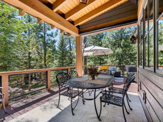 Enjoy the serene mountain views from this expansive covered deck, perfect for outdoor dining and relaxation.