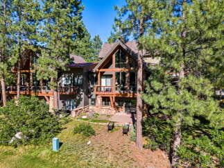 Nestled among tall pine trees, this stunning mountain home offers a luxurious retreat.
