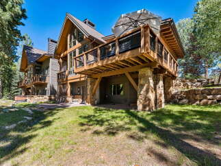 Experience luxury mountain living in this stunning timber-frame home, nestled amidst towering pines and featuring expansive decks perfect for enjoying the serene surroundings.