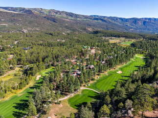 Experience luxury living nestled amidst a picturesque golf course and stunning mountain vistas.