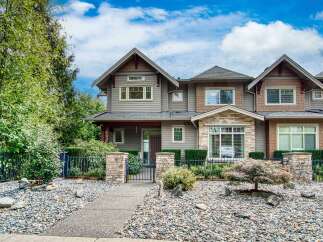 Discover this stunning townhouse featuring a modern exterior with stone and wood accents.