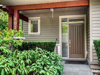 Welcome to this charming home featuring a welcoming covered porch with a prominent address number '107'.