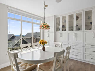 Enjoy bright and airy meals in this charming dining area, featuring a large window with scenic views and a beautiful stained-glass pendant light.