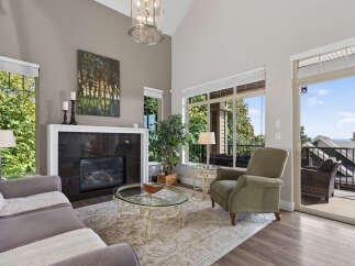 Experience breathtaking views from this stunning living room, featuring a grand fireplace and vaulted ceilings.