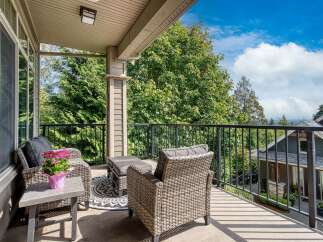 Enjoy breathtaking views from this covered balcony, perfect for outdoor relaxation and entertaining.